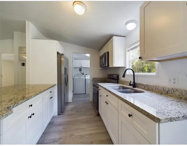 a large kitchen with a granite countertop sink and a refrigerator