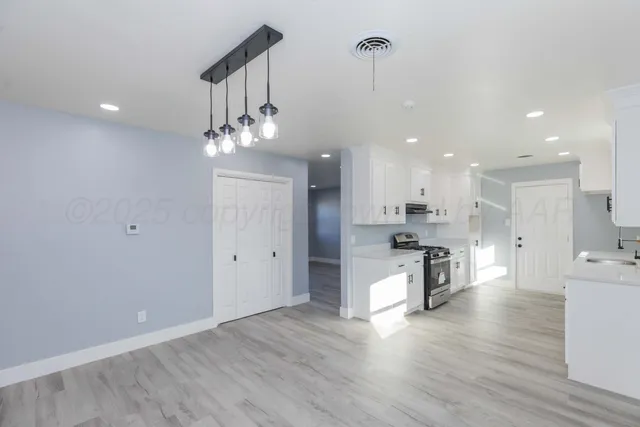 a view of kitchen with sink and refrigerator