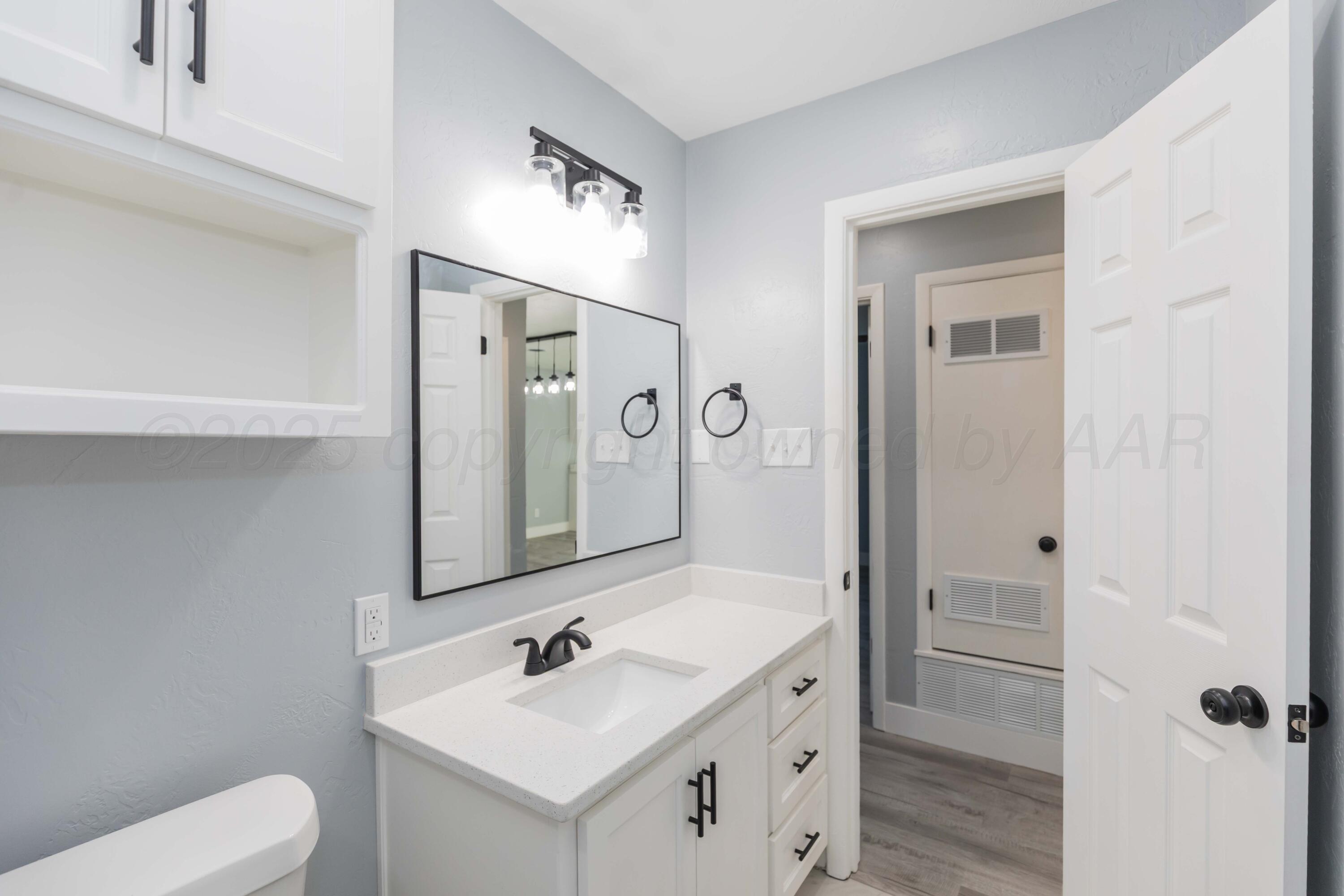 3108 Oak Drive Amarillo, TX 79107 - Photo 15 of 35 a bathroom with a toilet sink and mirror