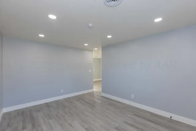 a view of an empty room with wooden floor