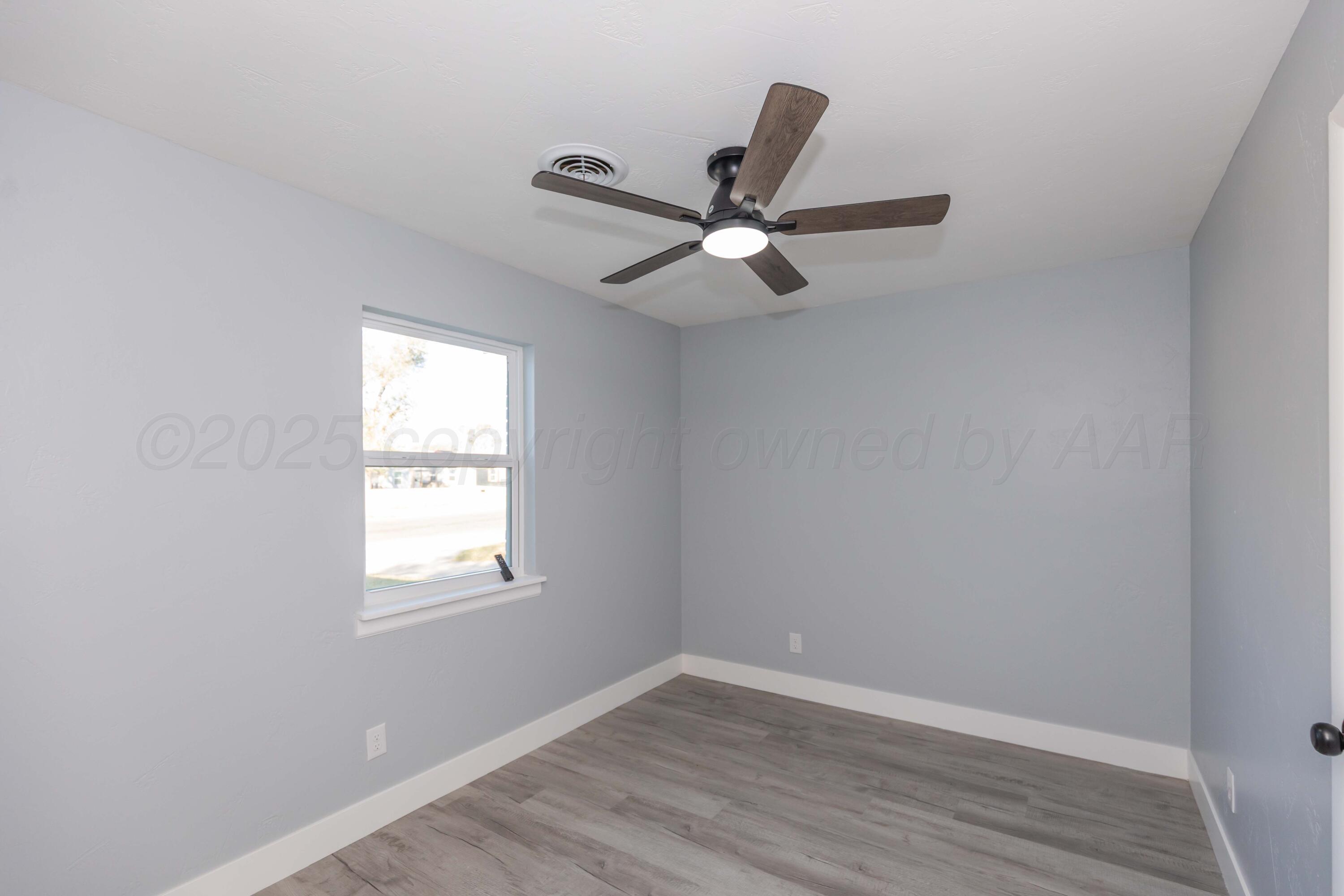 3108 Oak Drive Amarillo, TX 79107 - Photo 26 of 35 an empty room with wooden floor fan and windows