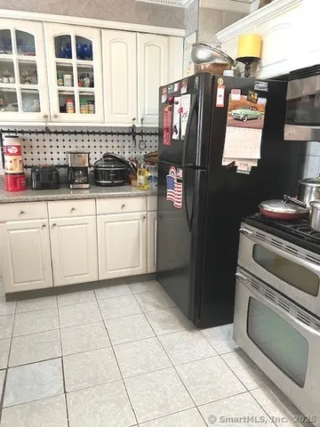 a kitchen with a stove a refrigerator and storage