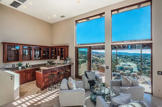 a living room with furniture kitchen view and a chandelier