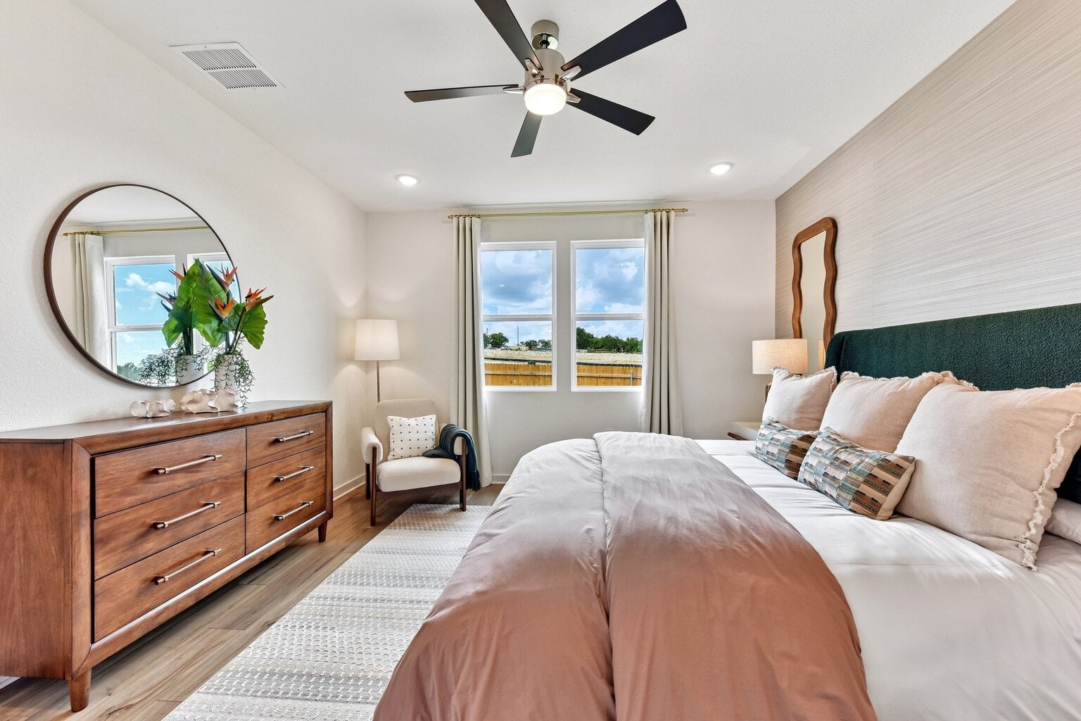 10609 Trifecta Way Buda, TX 78610 - Photo 5 of 17 Well-lit bedroom features ample natural light and a contemporary ceiling fan, providing comfort and style.