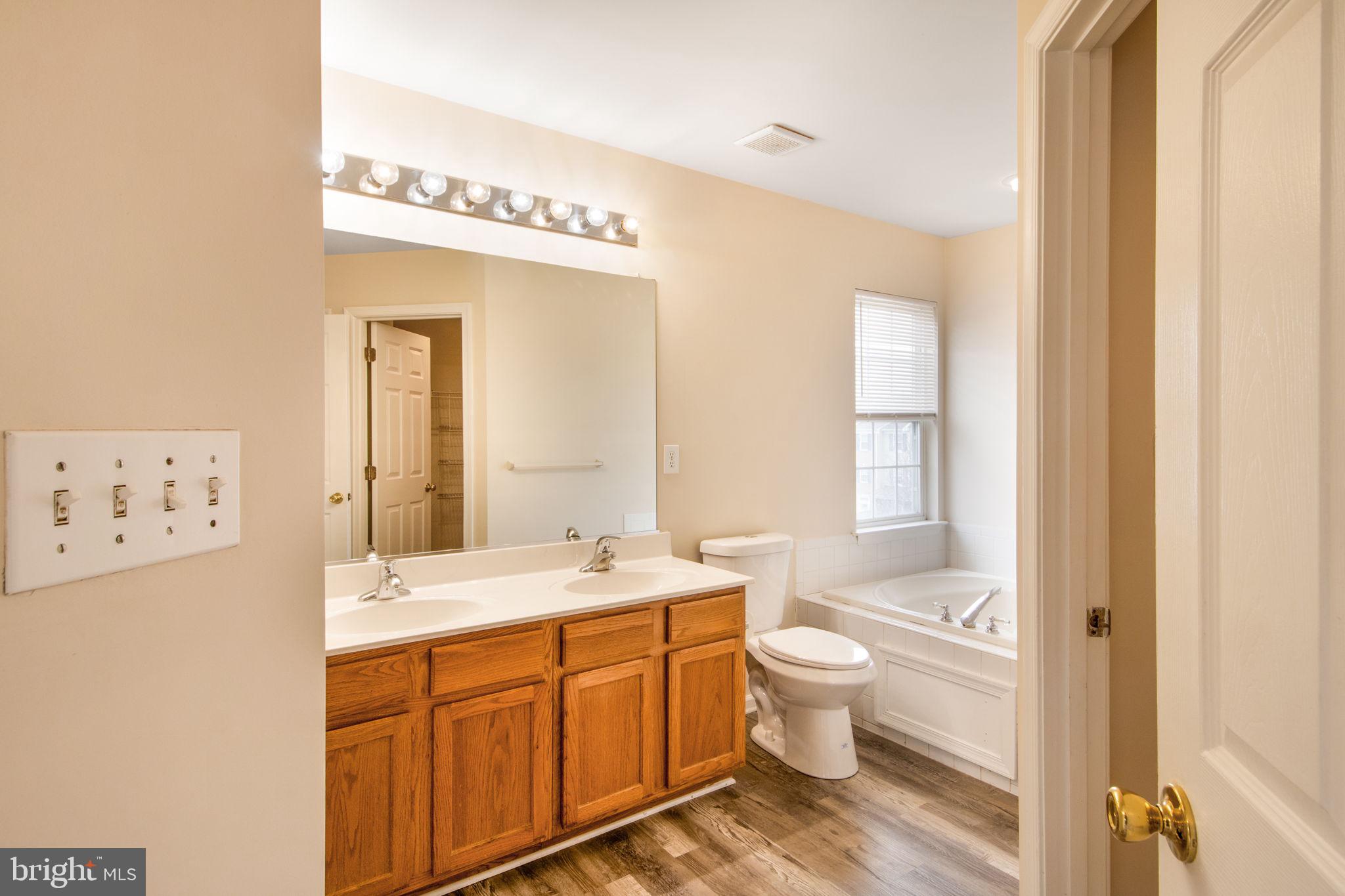 5171 Duke Court Frederick, MD 21703 - Photo 22 of 26 a spacious bathroom with a double vanity sink mirror and toilet