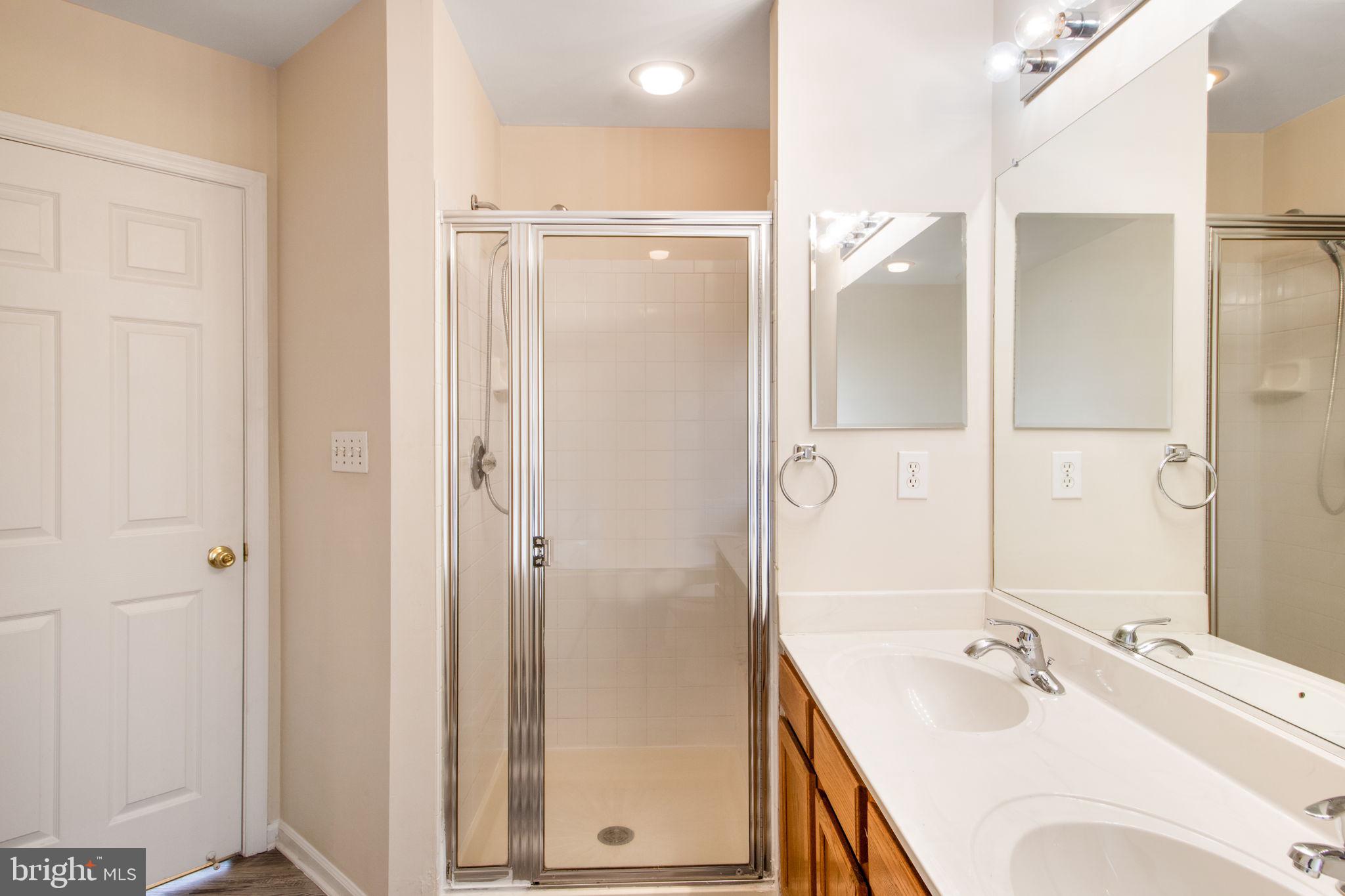5171 Duke Court Frederick, MD 21703 - Photo 24 of 26 a bathroom with a bathtub shower sink vanity and a mirror