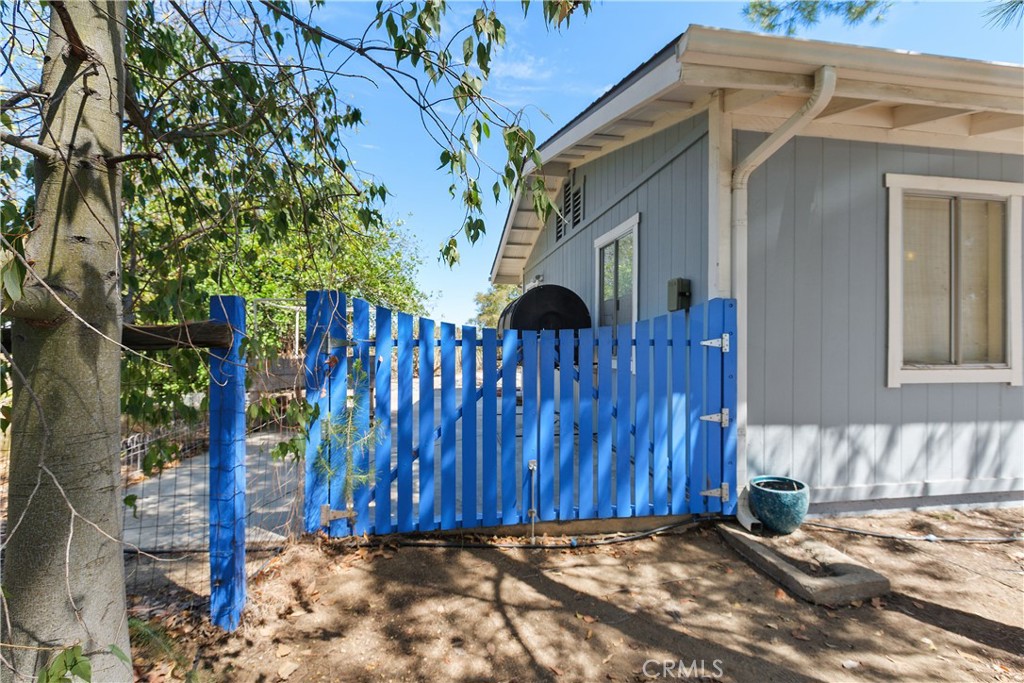 34881 Los Nogales Road Temecula, CA 92592 - Photo 42 of 50 Side gate entry to the concrete patio, composting bin, a raised vegetable garden structure.