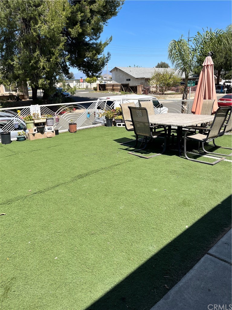 371 Redbud Place Perris, CA 92570 - Photo 3 of 27 a view of a swimming pool with lawn chairs and a big yard