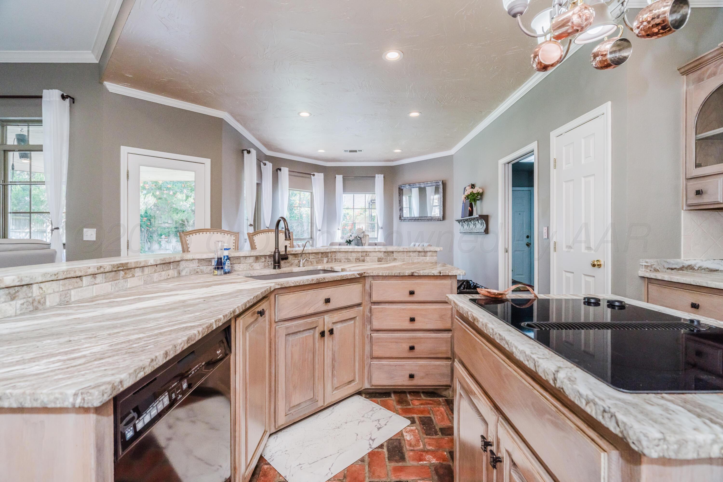 8216 Progress Drive Amarillo, TX 79119 - Photo 13 of 58 a large kitchen with a large counter top a sink a window and stainless steel appliances