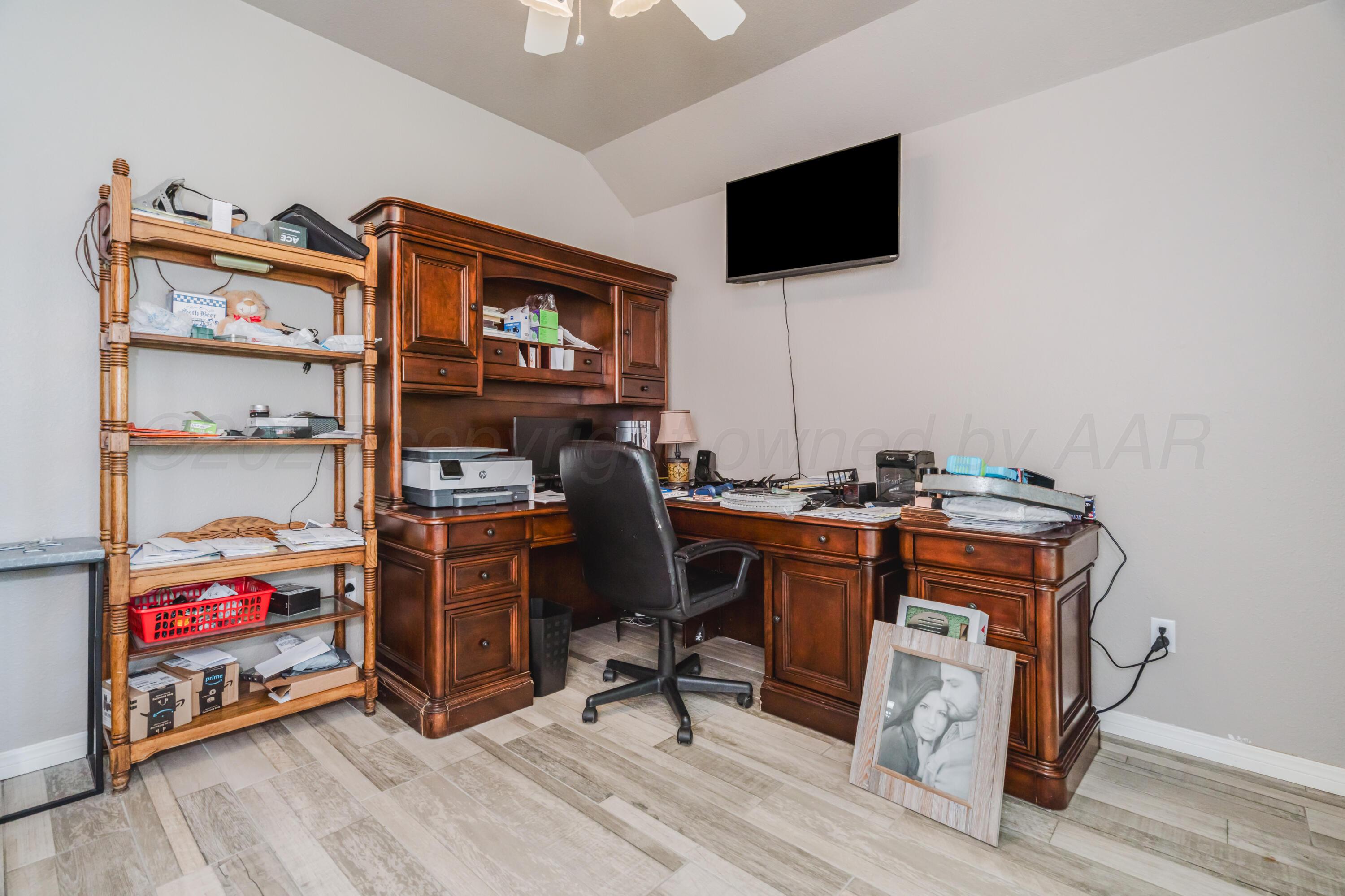 8216 Progress Drive Amarillo, TX 79119 - Photo 23 of 58 a view of a workspace with furniture and a flat screen tv
