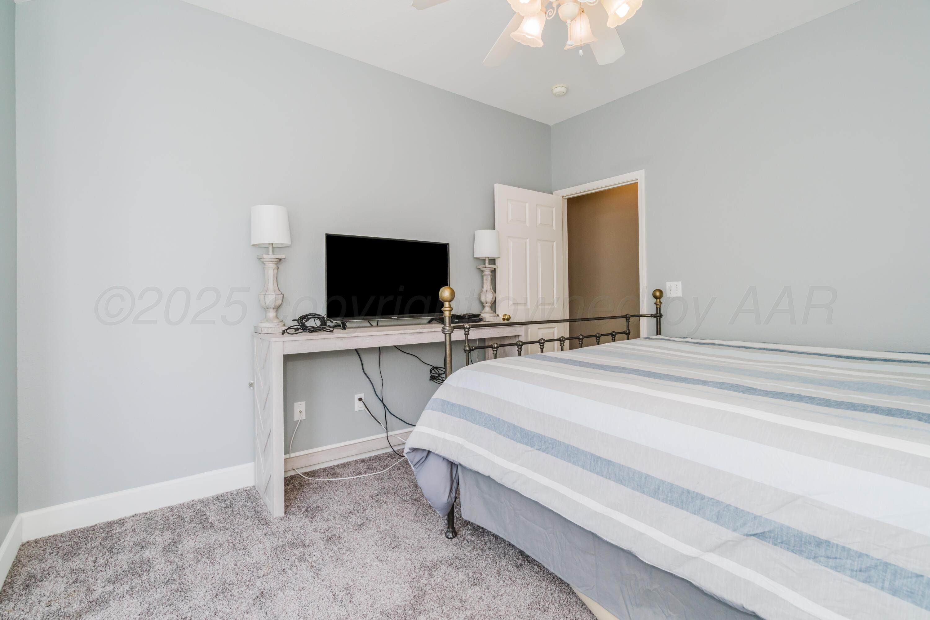 8216 Progress Drive Amarillo, TX 79119 - Photo 29 of 58 a spacious bedroom with a bed and a flat screen tv