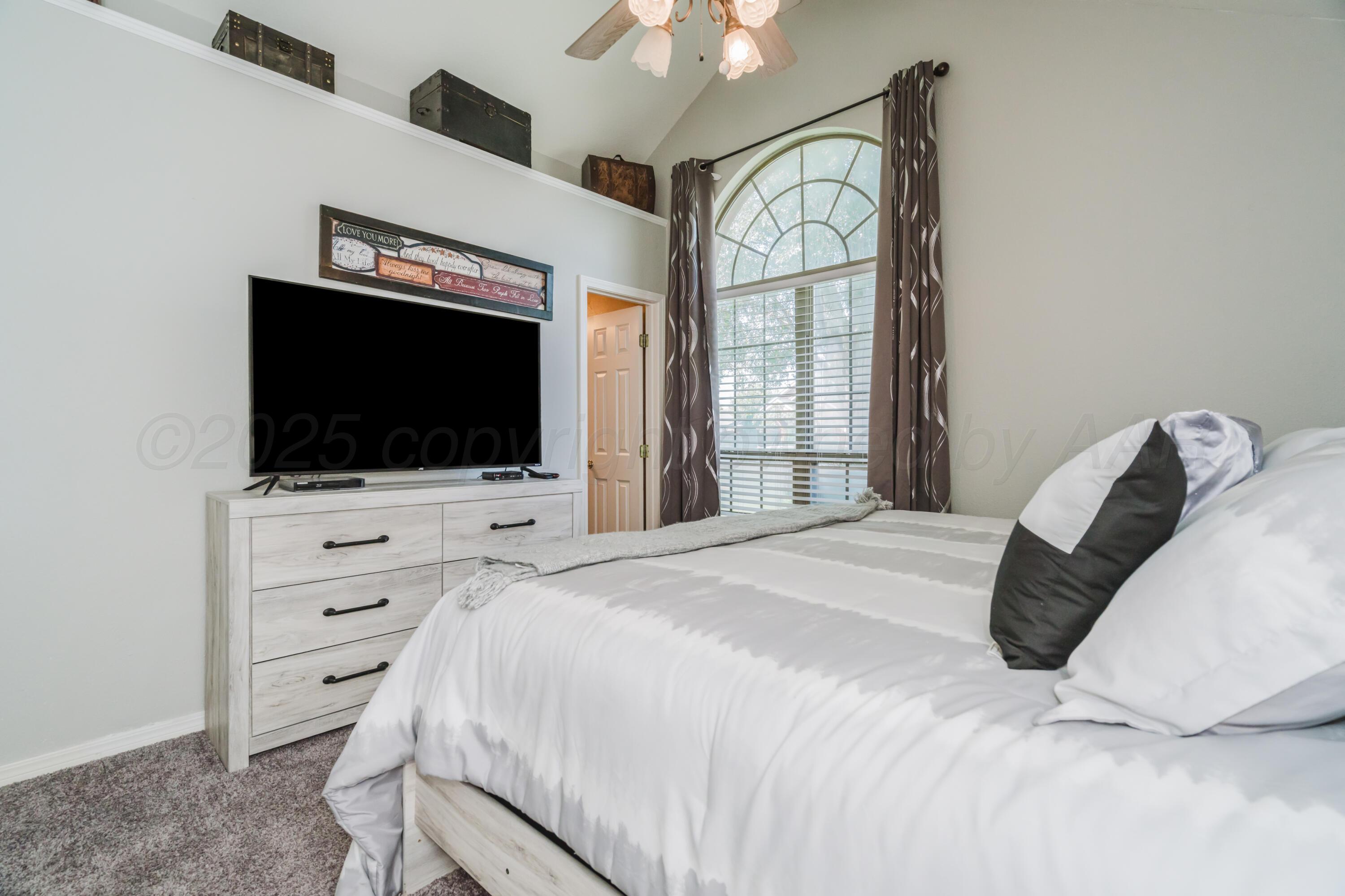 8216 Progress Drive Amarillo, TX 79119 - Photo 34 of 66 a bedroom with a bed and a flat screen tv
