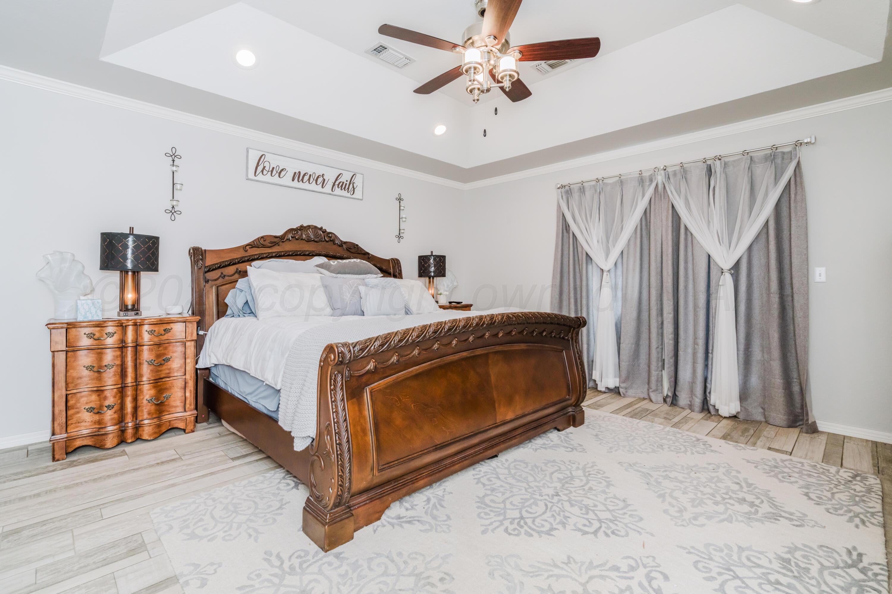 8216 Progress Drive Amarillo, TX 79119 - Photo 35 of 58 a bedroom with a bed and a chandelier