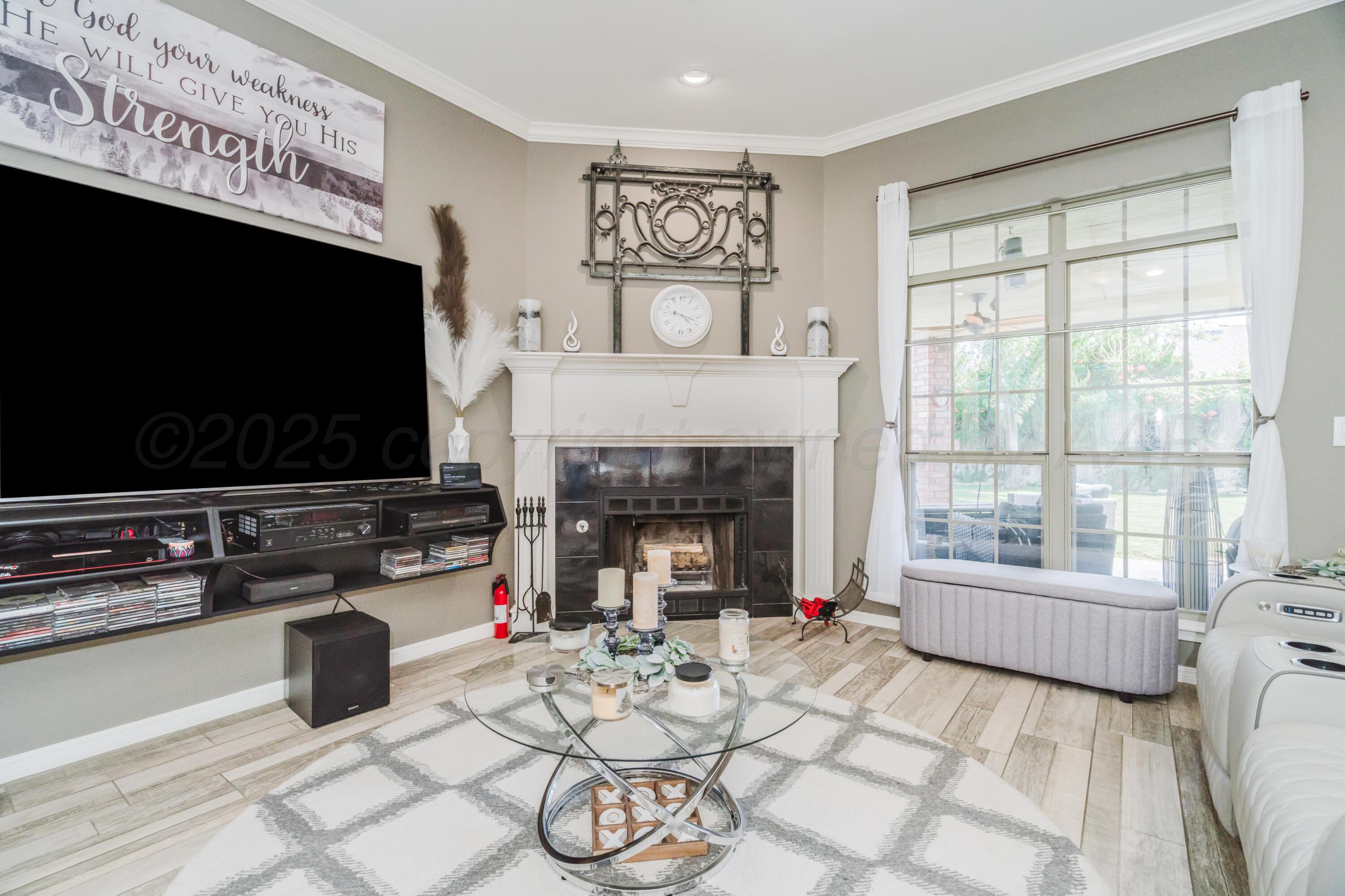 8216 Progress Drive Amarillo, TX 79119 - Photo 10 of 58 a living room with furniture a flat screen tv and a fireplace