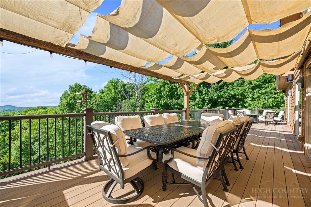 331 Alpine Road Blowing Rock, NC 28605 - Photo 4 of 50 a view of a patio with table and chairs with wooden floor and fence