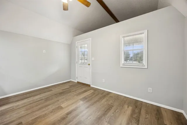 a view of an empty room with wooden floor