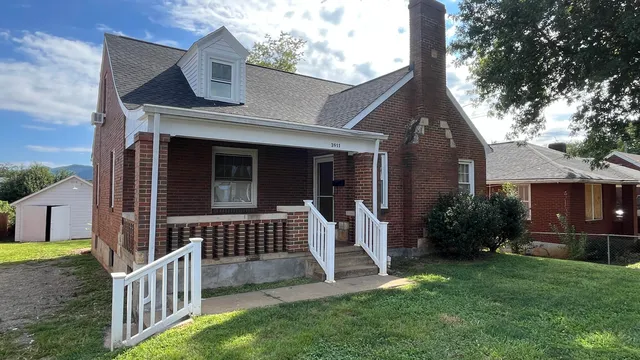 a view of house with a yard and porch