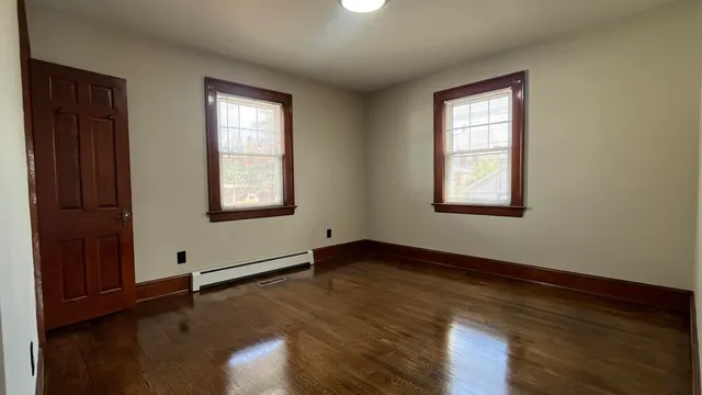 an empty room with wooden floor and closet