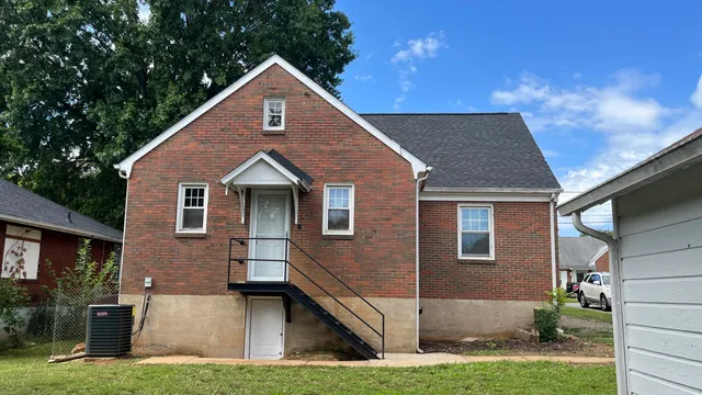 an empty room with wooden floor closet and windows