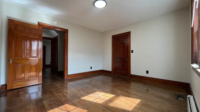 a view of empty room with wooden floor