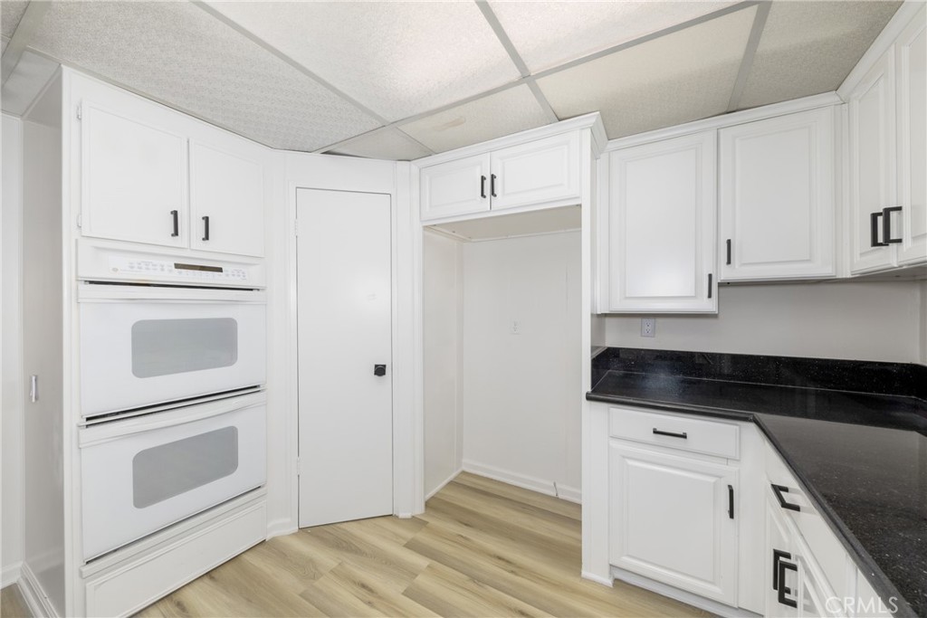 40975 Laredo Trail Cherry Valley, CA 92223 - Photo 8 of 34 a kitchen with white cabinets and white appliances