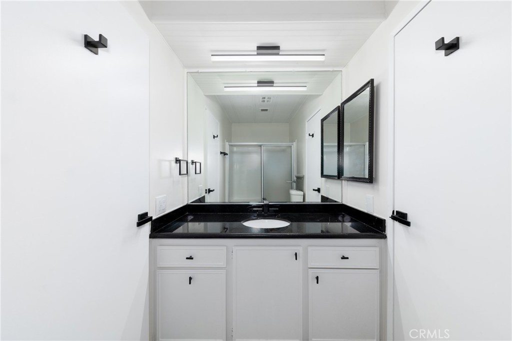 40975 Laredo Trail Cherry Valley, CA 92223 - Photo 10 of 34 a bathroom with a granite countertop sink and a mirror