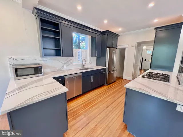 a kitchen with stainless steel appliances kitchen island granite countertop a stove a sink and a microwave