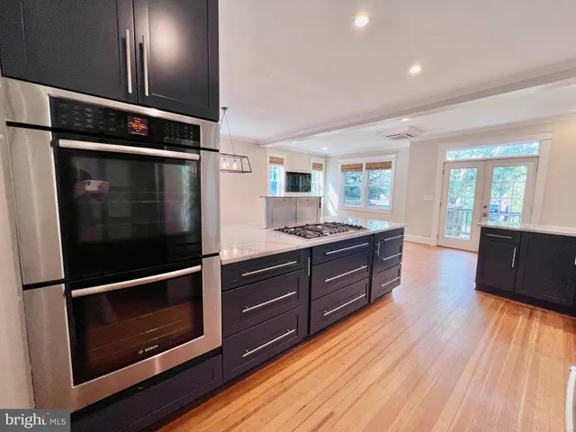 a kitchen with stainless steel appliances a refrigerator and wooden floor