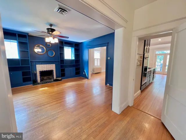 a view of a livingroom with a fireplace a chandelier and wooden floor