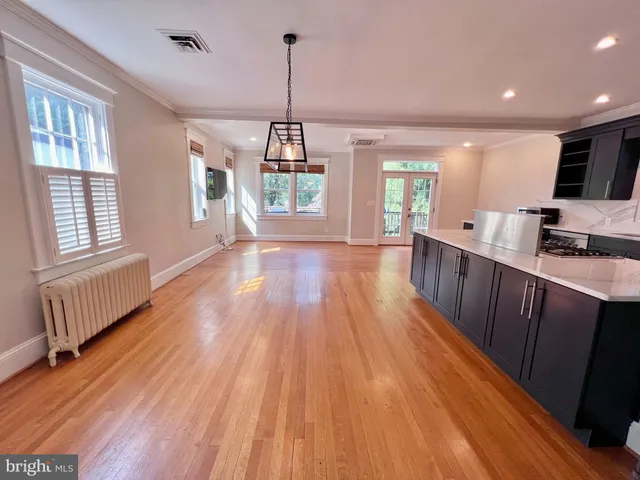 a kitchen with stainless steel appliances granite countertop a sink window and wooden floor