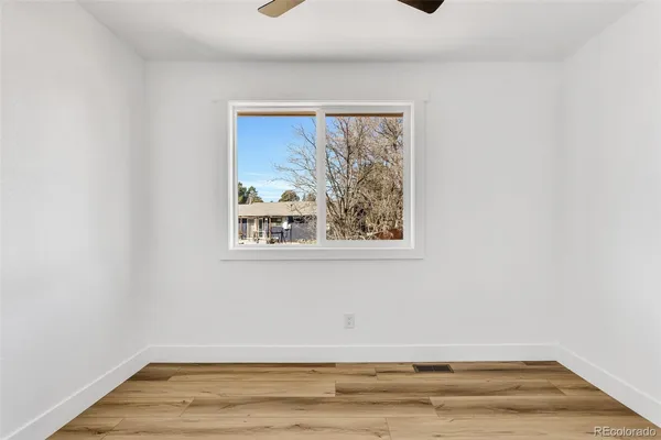 a view of a small space with wooden floor and a window