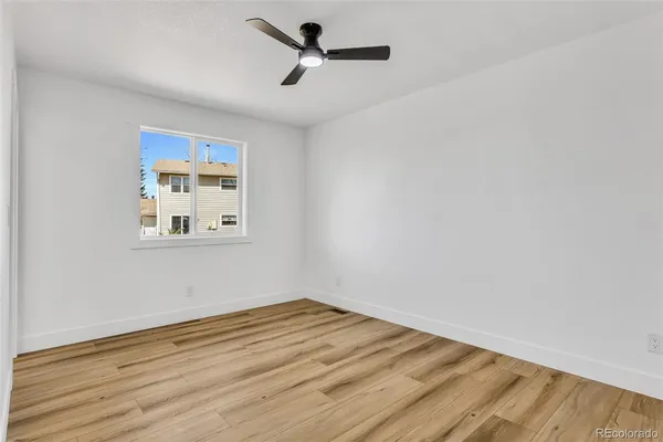 a view of empty room with wooden floor