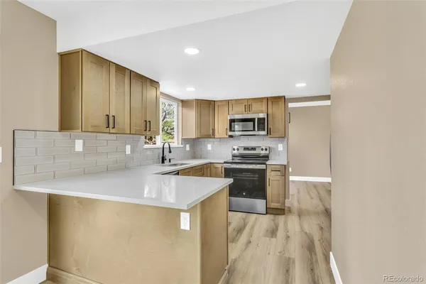 a kitchen with stainless steel appliances granite countertop a sink stove and refrigerator