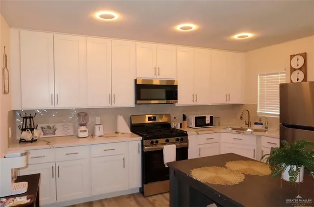 a kitchen with a sink a microwave a stove and refrigerator