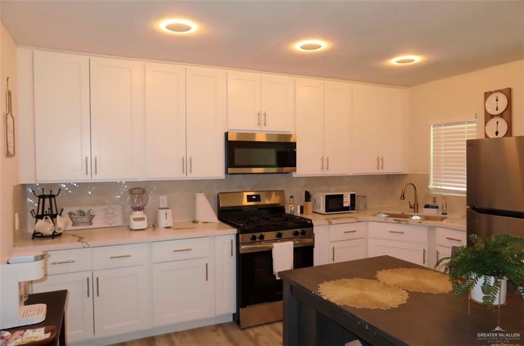 2617 Daytona Avenue McAllen, TX 78503 - Photo 6 of 17 a kitchen with a sink a microwave a stove and refrigerator