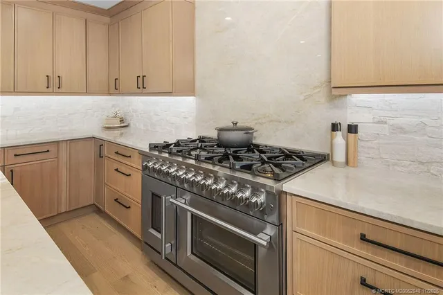a kitchen with stainless steel appliances a dining table chairs and a refrigerator