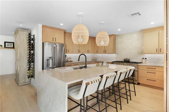 a kitchen with stainless steel appliances granite countertop a stove a sink and a refrigerator