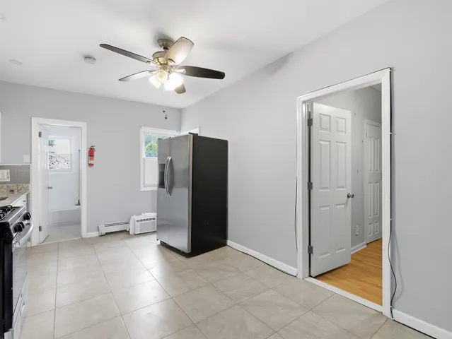 a view of a livingroom with a ceiling fan and refrigerator
