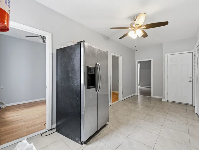 a view of a refrigerator in kitchen and an empty room