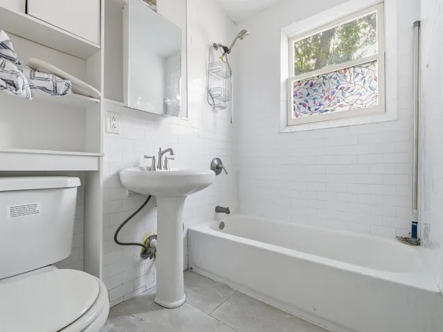 a bathroom with a sink a mirror toilet and bathtub