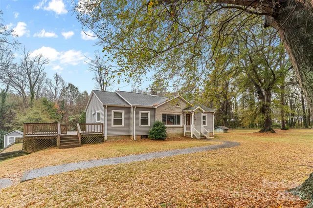 a front view of a house with a yard covered with trees