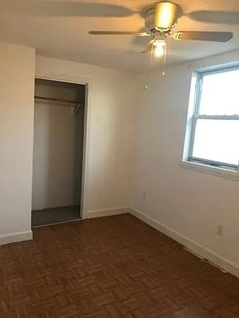 32 Wamesit Street, Unit 2 Lowell, MA 01852 - Photo 5 of 9 an empty room with windows and fan
