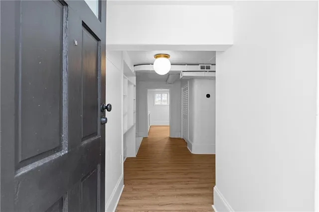 a view of a hallway with wooden floor
