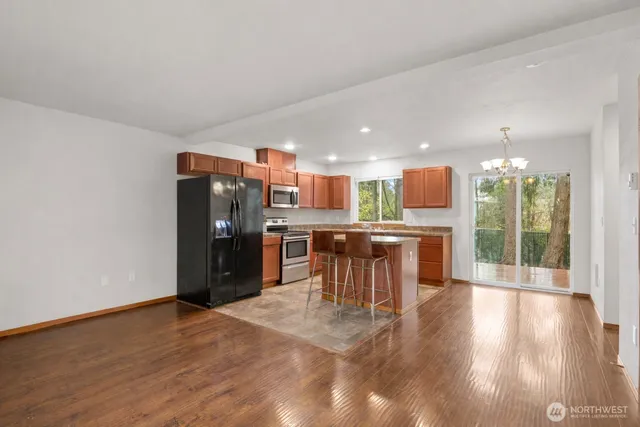 a kitchen with stainless steel appliances kitchen island granite countertop a refrigerator and a sink