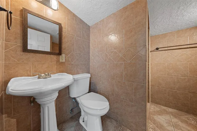 a bathroom with a sink toilet and mirror