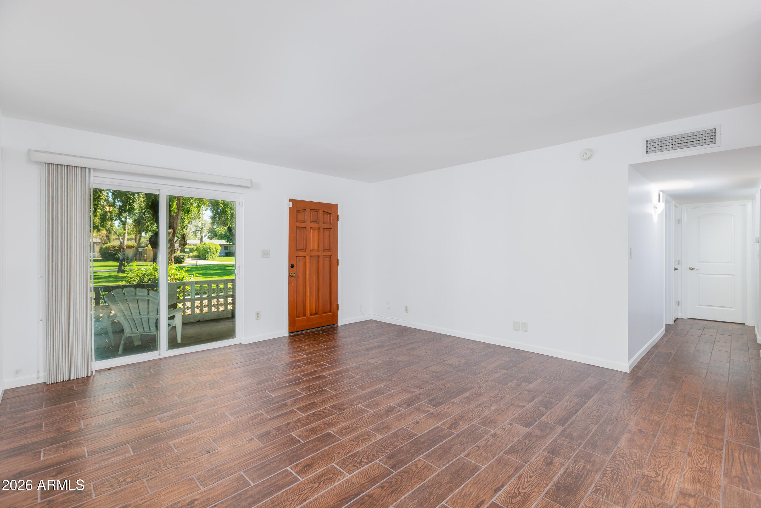 5550 North 12th Street, Unit 8 Phoenix, AZ 85014 - Photo 3 of 25 a view of an empty room with wooden floor and a window