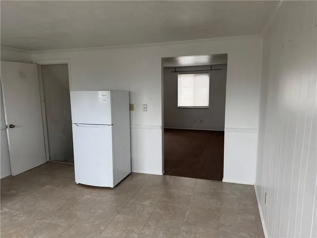 a view of an empty room with a kitchen