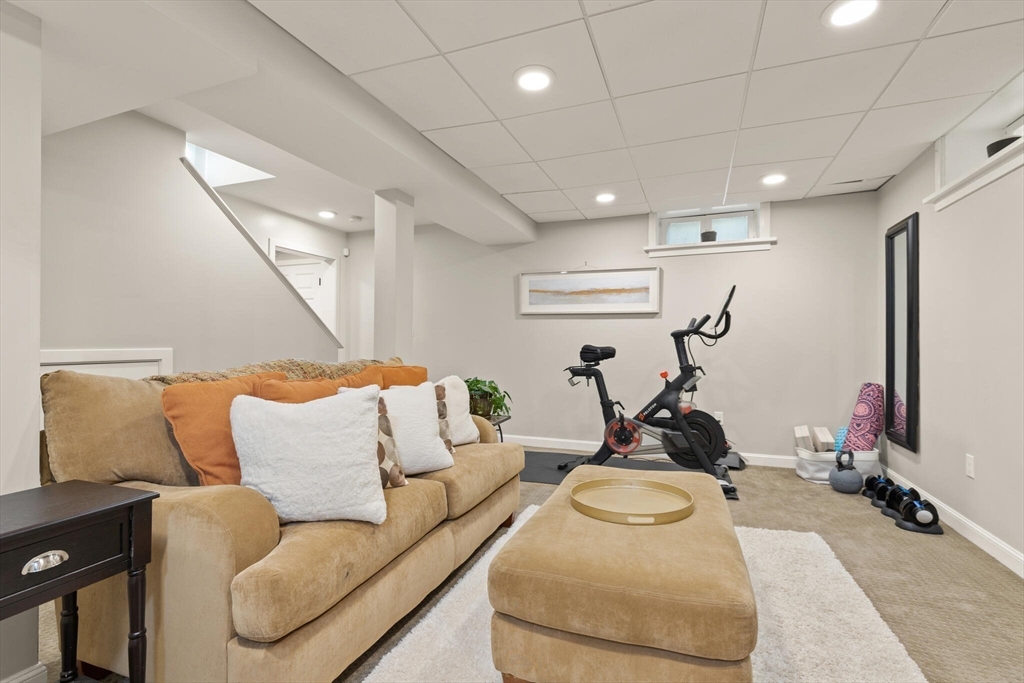 60 Amherst Road Newton, MA 02468 - Photo 22 of 25 a living room with furniture a mirror and gym equipment