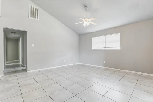 an empty room with fan and windows