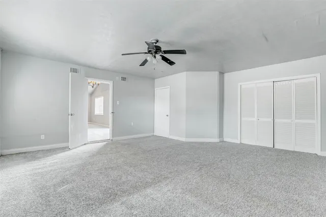 a view of empty room with ceiling fan
